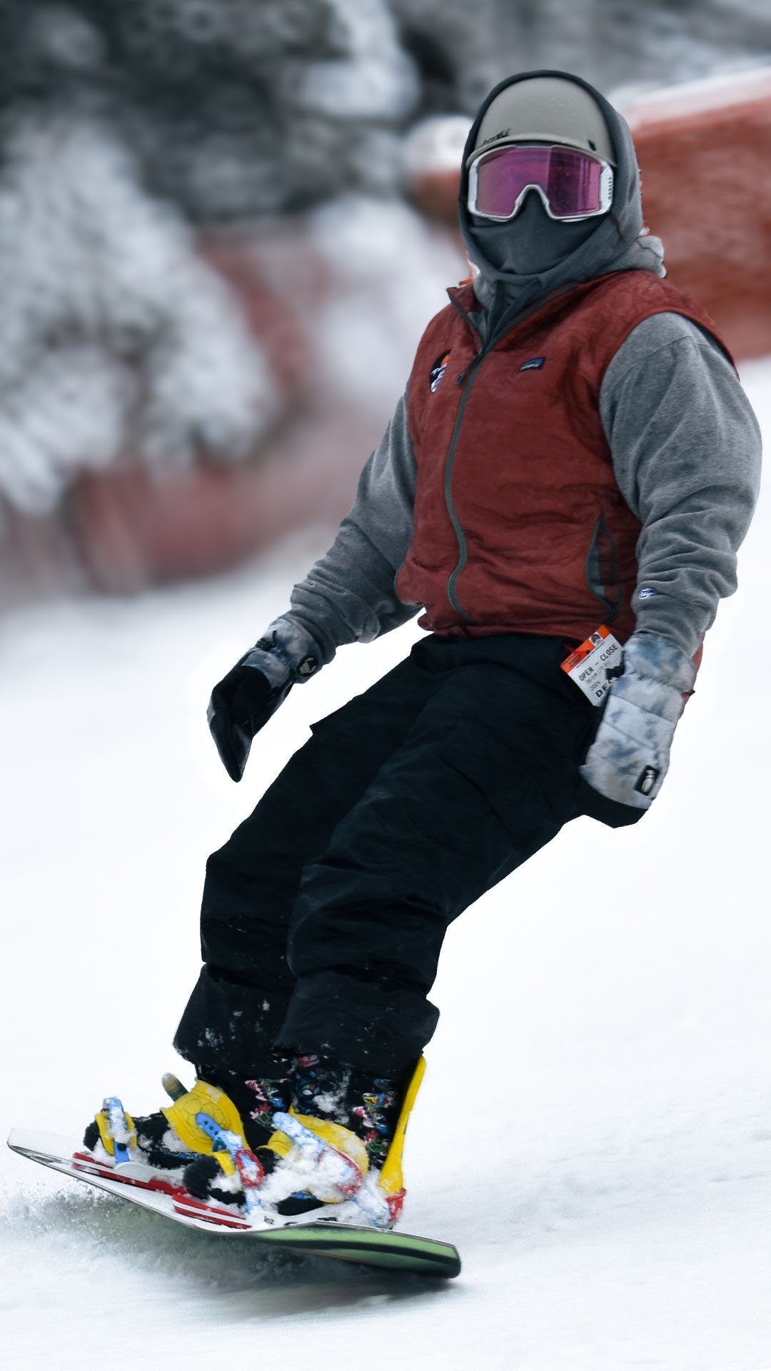 Snowboarder going down the mountain with gray, black and red on