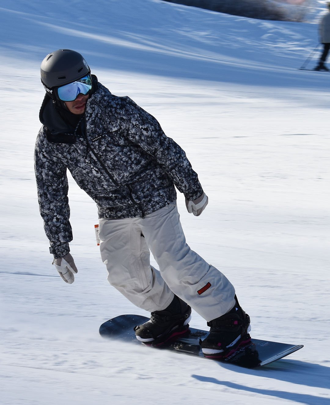 Someone wearing black and white going down the mountain