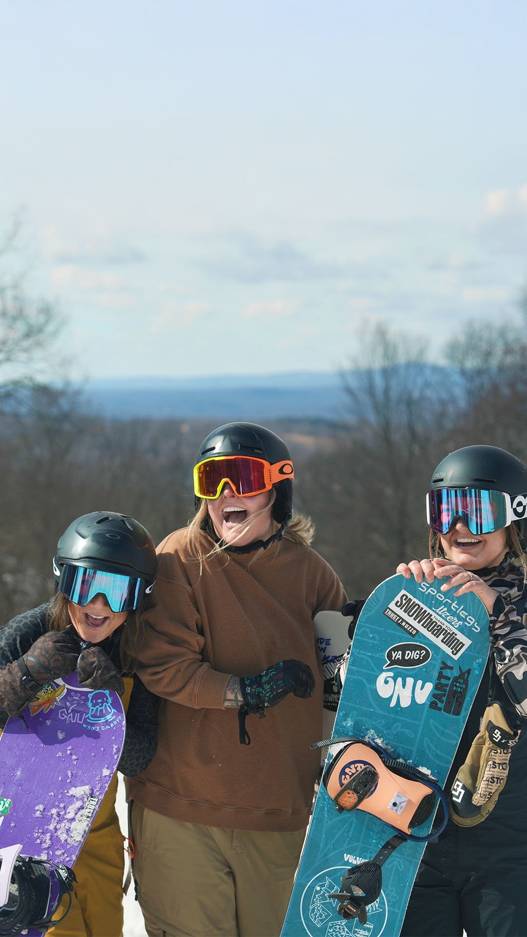 3 people wearing helmets and goggles while holding a snowboard