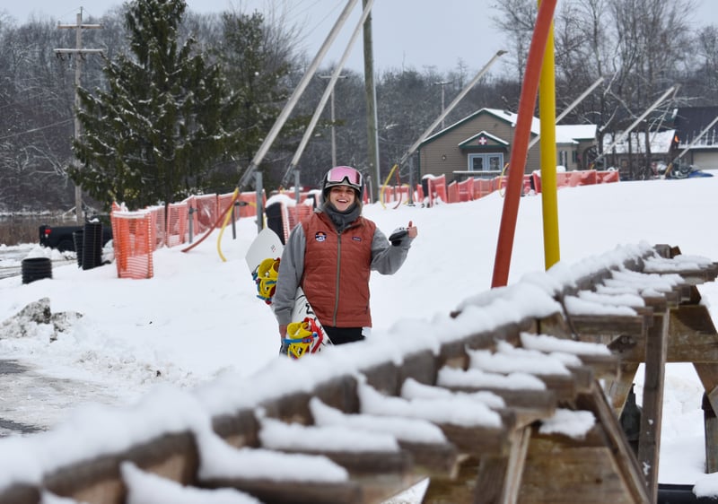 003 – Copy girl with snowboard smiling at camera