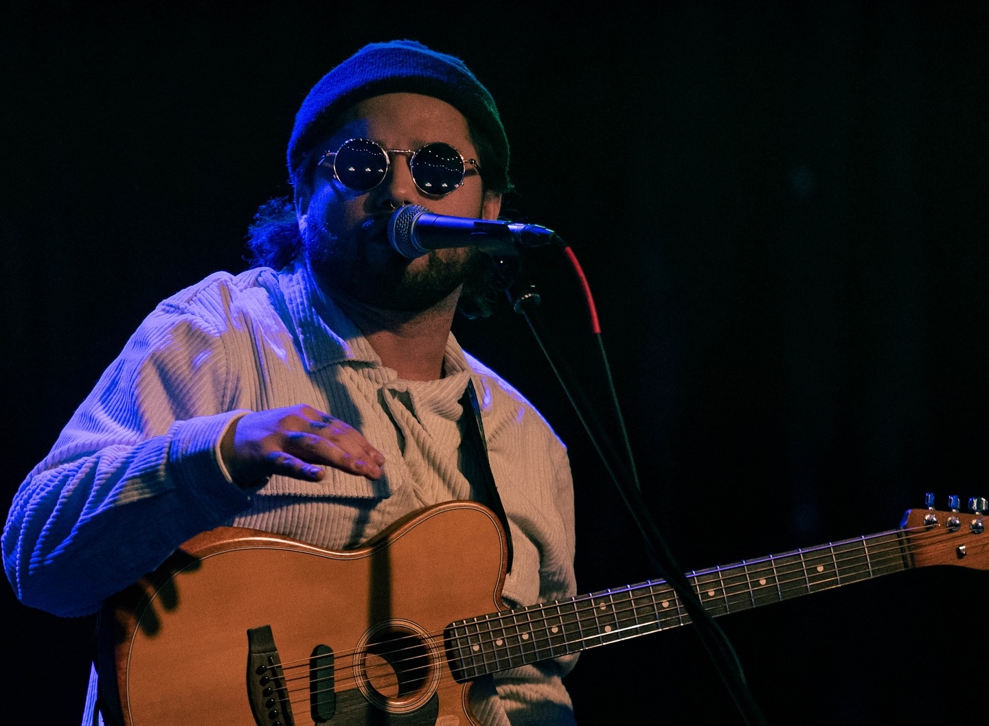 Guy singing with guitar and mic