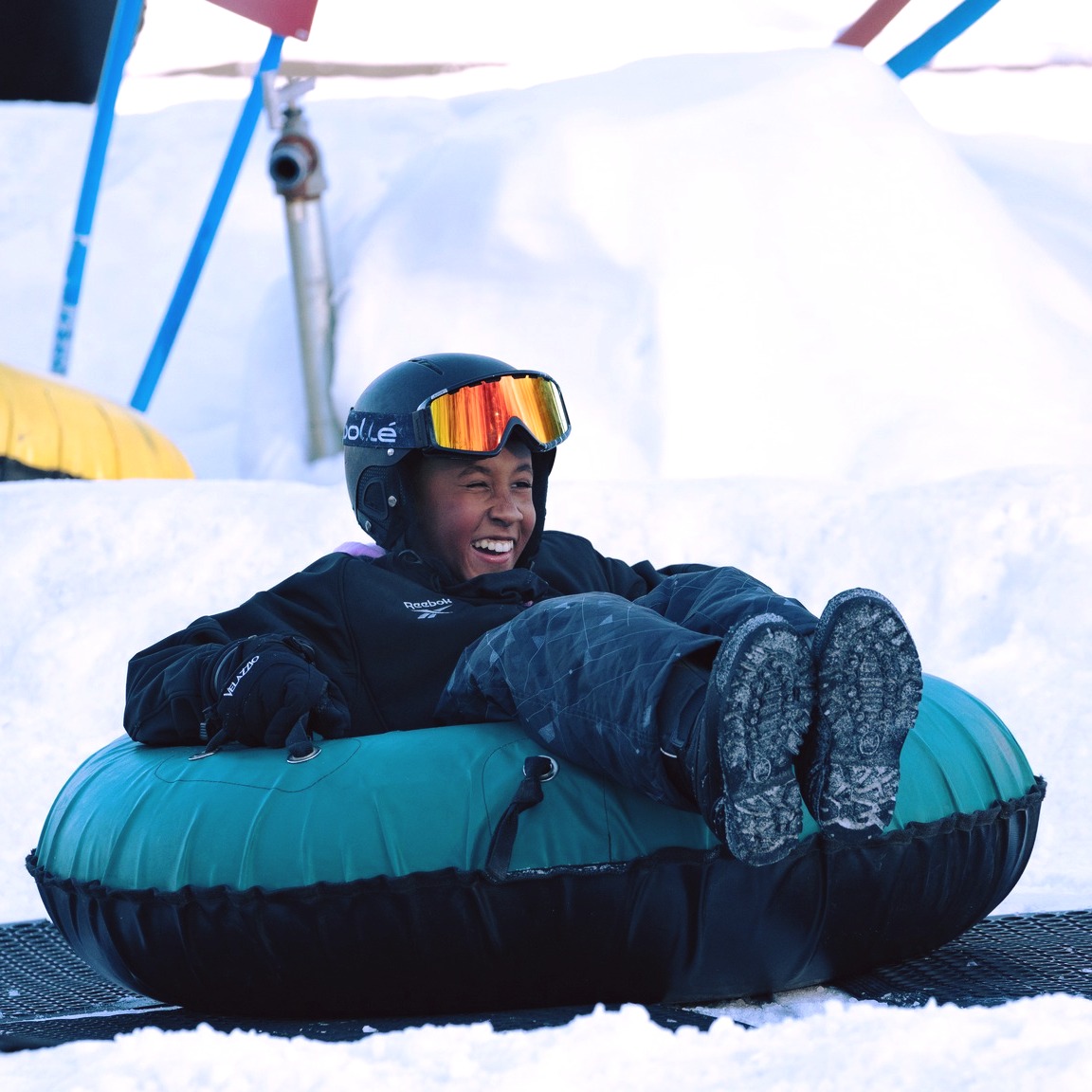 A guest smiling while snow tubing at Shawnee Mountain